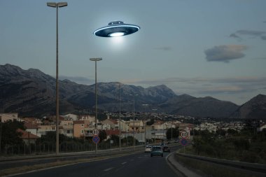 Uzaylı uzay gemisi şehrin üzerinde uçuyor. UFO, dünya dışı ziyaretçiler.