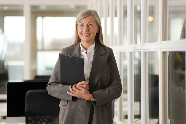 Smiling woman with clipboard in office. Lawyer, businesswoman, accountant or manager
