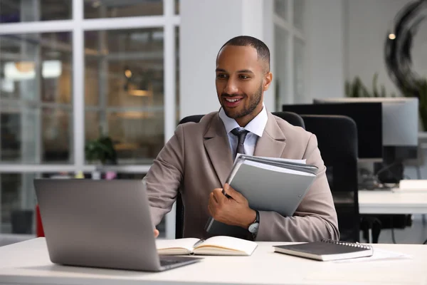 Happy man with folders working at table in office. Lawyer, businessman, accountant or manager