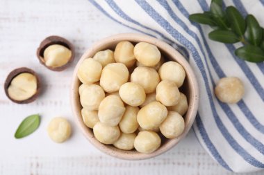 Lezzetli soyulmuş Macadamia fındıkları tabakta, ışık masasında, düz yatıyordu.