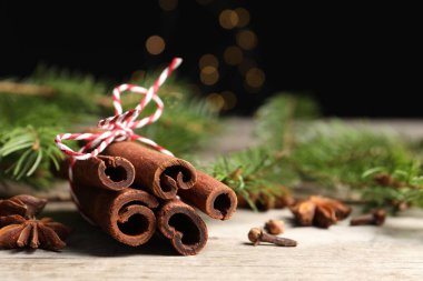 Ahşap masada farklı baharatlar ve köknar dalları, yakın plan.