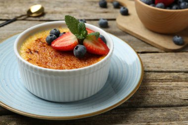 Böğürtlenli ve nane şekerli nefis creme brulee ahşap masada, yakın plan