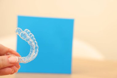 Bulanık arka planda, saydam diş hizalayan kadın, yakın plan. Metin için boşluk