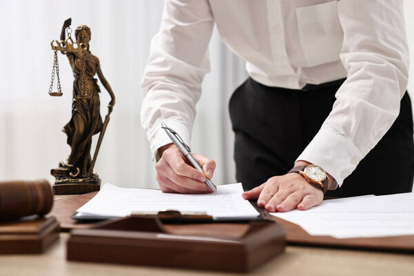 Lawyer working with documents at table in office, closeup