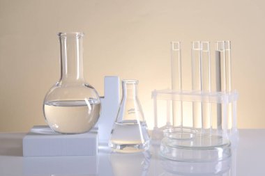 Laboratuvar analizi. Bej arkaplanda farklı cam eşyalar