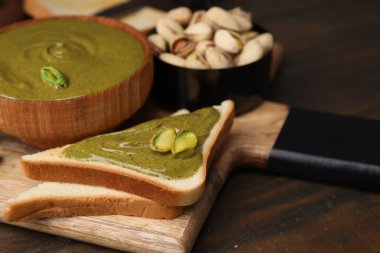 Lezzetli fıstık kremalı tostlar ve ahşap masada fındıklar, yakın plan.