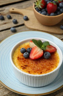 Böğürtlenli ve nane şekerli nefis creme brulee ahşap masada, yakın plan