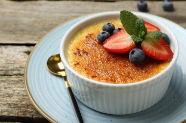 Böğürtlenli ve nane şekerli nefis creme brulee ahşap masada, yakın plan