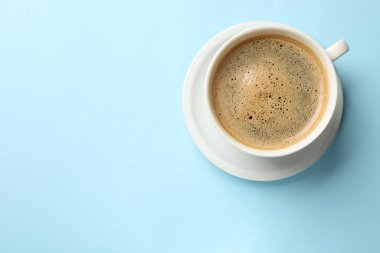 Açık mavi arka planda, fincanda Aromatik kahve, üst manzara. Metin için boşluk