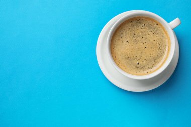 Açık mavi arka planda, fincanda Aromatik kahve, üst manzara. Metin için boşluk