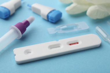 Açık mavi arkaplan üzerinde Covid-19 ekspres test kiti, yakın plan