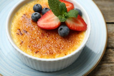 Böğürtlenli ve nane şekerli nefis creme brulee ahşap masada, yakın plan