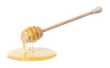 Beyaz arka planda doğal bal damlıyor.