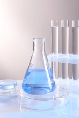 Laboratuvar analizi. Aydınlık arkaplan karşısında farklı cam eşyalar