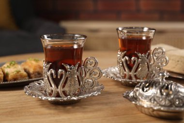 Geleneksel Türk çayı ahşap masaya konmuş klasik çay setinde servis edilir.