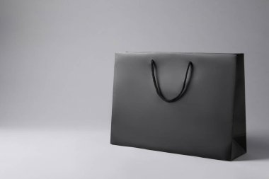 Açık gri arkaplanda siyah kağıt çanta, metin için boşluk