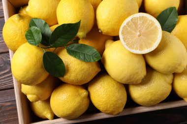 Tahta masada sandıkta taze limonlar, üst manzara.