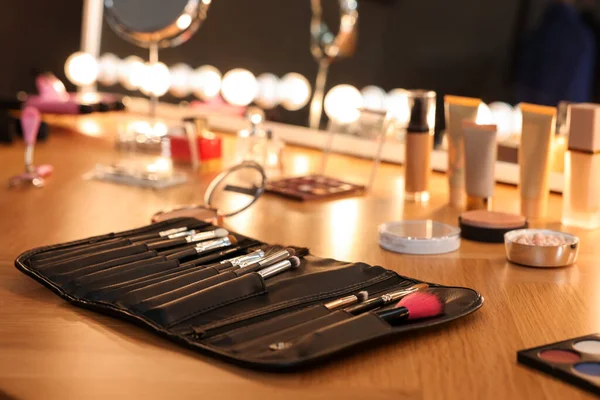 Ahşap masada makyaj fırçası ve kozmetik seti.