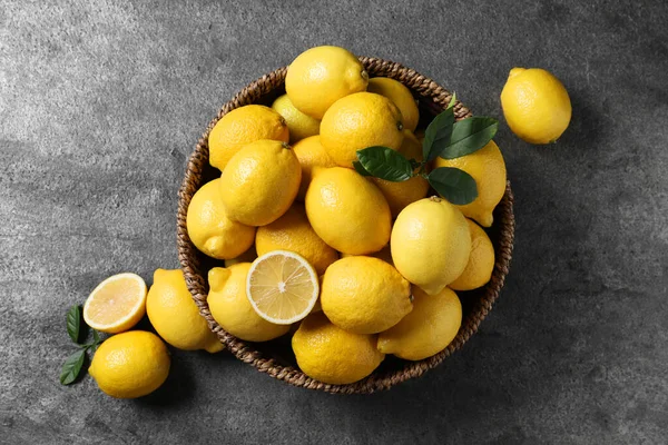 Hasır sepetteki taze limonlar Gri masada, üst manzara