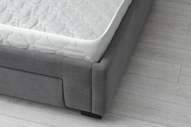 Gri yatağın üzerinde yeni yumuşak bir yatak, yakın plan. Metin için boşluk