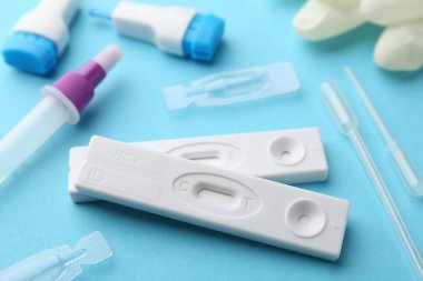 Açık mavi arkaplanda tek kullanımlık test kitleri, yakın plan