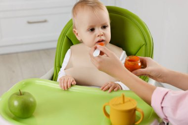 Anne, küçük bebeğini sağlıklı yiyeceklerle besliyor.