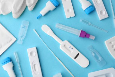 Açık mavi arkaplan üzerinde tek kullanımlık ekspres test kitleri, düz yatıyordu