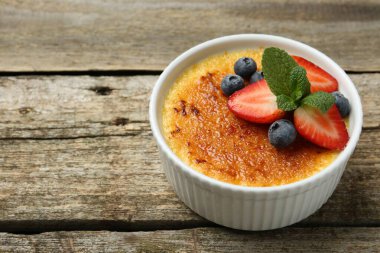 Böğürtlenli nefis creme brulee ve ahşap masada nane şekeri, yakın plan. Metin için boşluk