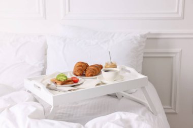 İyi sabahlar. Evde yatakta lezzetli bir kahvaltı tepsisi.