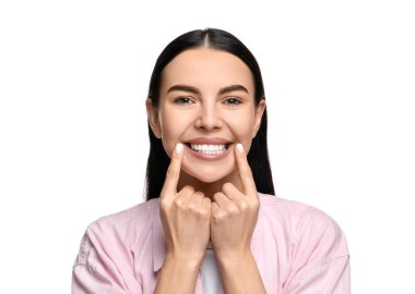 Temiz dişleri olan güzel bir kadın beyaz arka planda gülümsüyor.