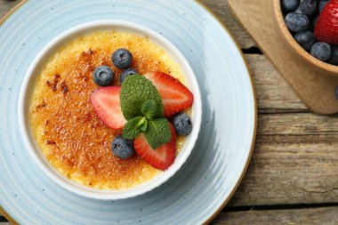 Böğürtlenli ve nane şekerli nefis creme brulee ahşap masada, üst manzara