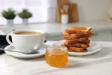 Kahvaltı mutfakta servis edilir. Taze tost, kahve ve bal beyaz mermer masada.