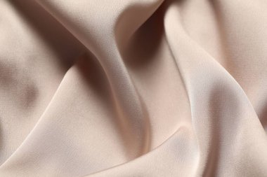 Arkaplan olarak bej rengi buruşuk ipek kumaş dokusu, üst görünüm