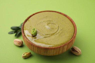 Fıstıklı krema kasede, fındıklı yeşil arka plan, yakın plan.