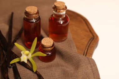 Aromatik vanilya özü, kapsüller ve masa örtüsü, yakın plan.