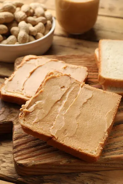 Tasty peanut butter sandwiches on wooden table, closeup view