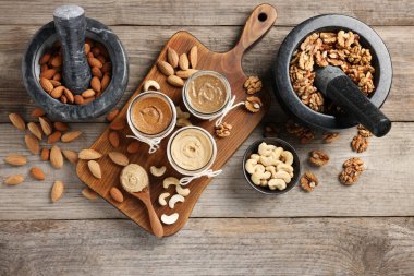 Farklı fıstıklardan fındık ezmesi yapıyorum. Ahşap masada yağlı bir bileşim var.