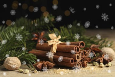 Farklı baharatlar ve ağaç dalları ahşap masada, yakın plan. Tarçın, anason, kakule, hindistan cevizi