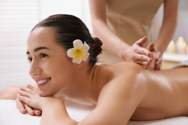 Spa salonundaki kanepede sırt masajı yaptıran kadın.