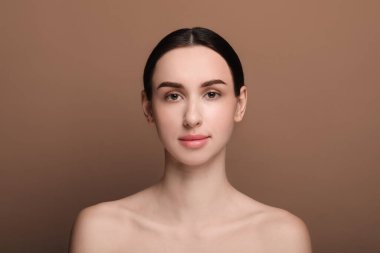 Kahverengi arka planda güzel bir genç kadının portresi