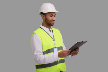 Gri arka planda elinde pano tutan sabit şapkalı mühendis.