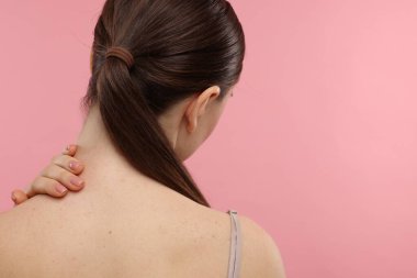 Pembe arka planda boynuna dokunan bir kadın. Metin için boşluk