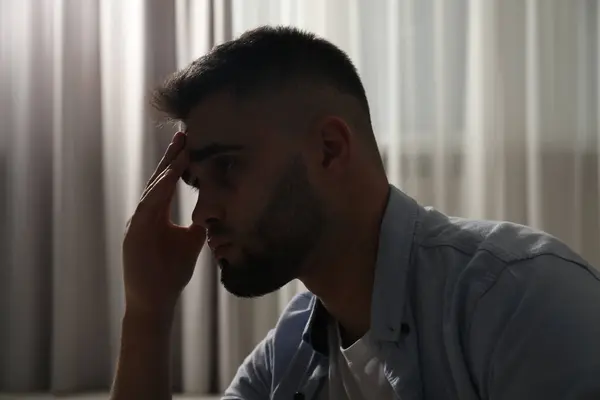 Sad young man near on blurred background