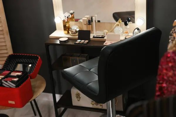 Makeup room. Chair near dressing table with different beauty products indoors