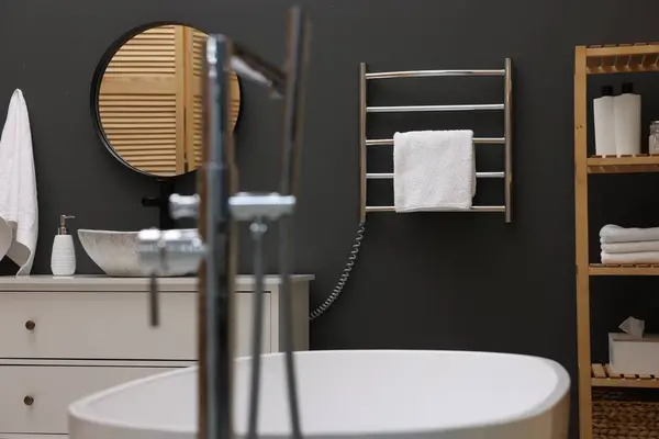 Stylish bathroom interior with heated towel rail and white tub