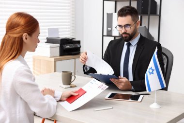 İsrail 'e göç. Elçilik çalışanı ofisteki kadın belgelerini kontrol ediyor.