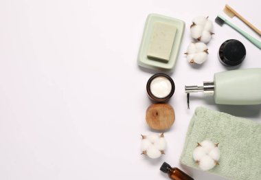 Banyo aksesuarları. Beyaz arka planda farklı kişisel bakım ürünleri ve pamuk çiçekleri, metin için yeri olan düz yatıyordu