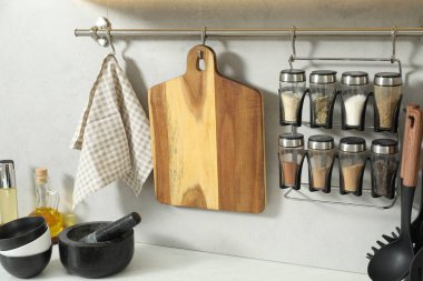 Mutfaktaki beyaz tezgahta tahta kesme tahtaları ve diğer mutfak aletleri.