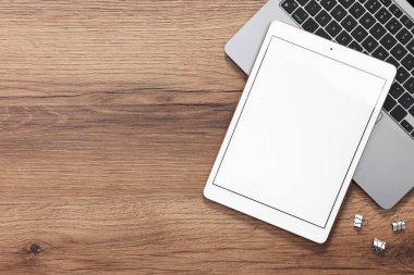 Modern tablet, dizüstü bilgisayar ve şarjörler tahta masada, düz yerde. Metin için boşluk