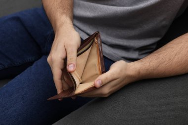 Kanepede cüzdanı boş bir adam, yakın plan.